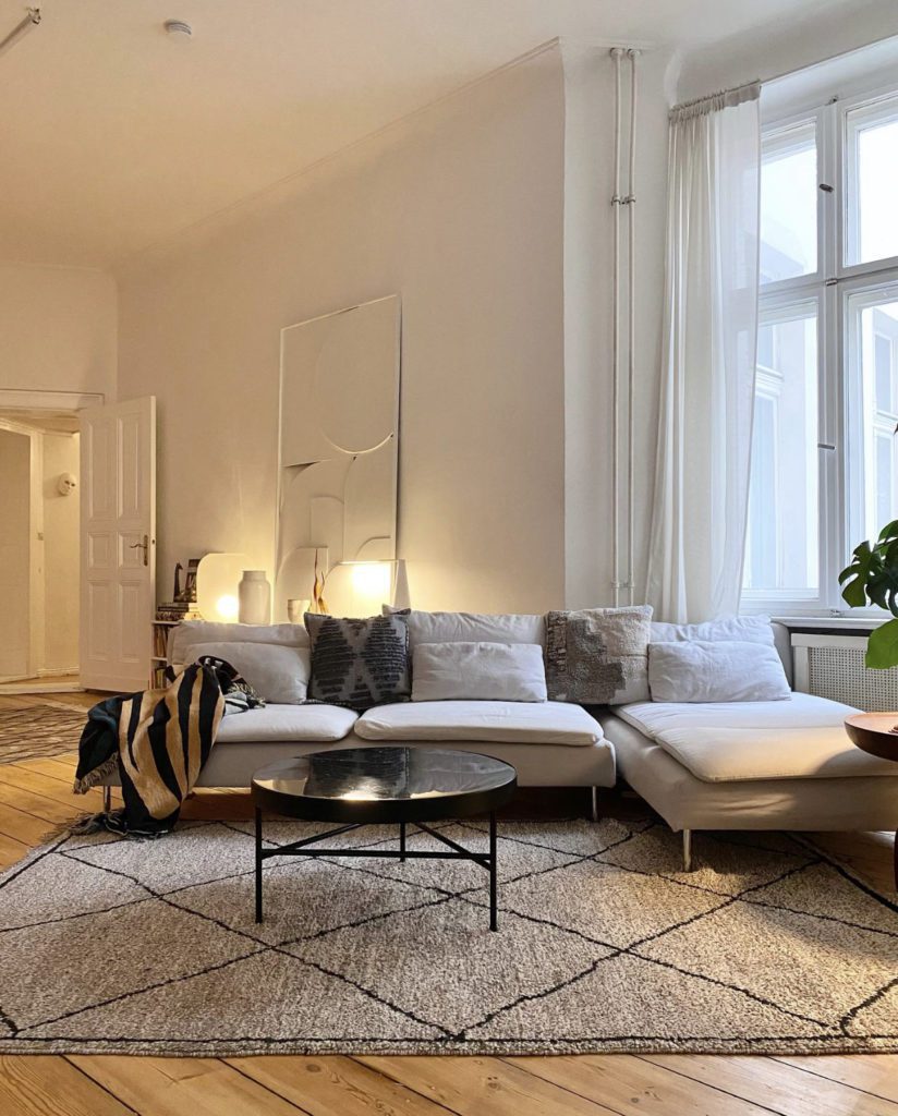 Wohnzimmer mit heller Couch und dunklem Couch-Tisch