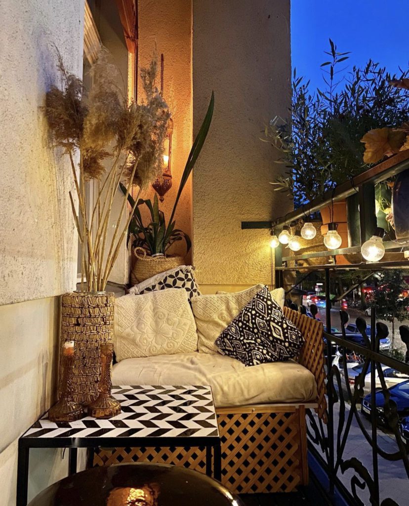 Balkon mit Sitzbank und Trockenblumen sowie Lichterkette