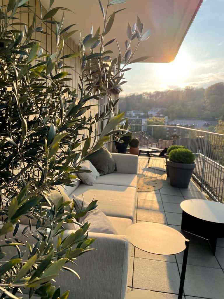 Sonniger Balkon mit Sitzlounge und Pflanzen