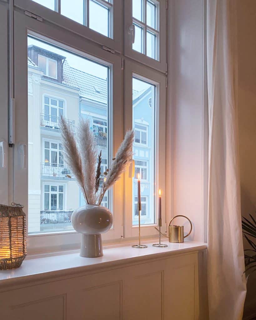 Fenster in Altbauwohnung mit weißer Vase und Trockenblumen