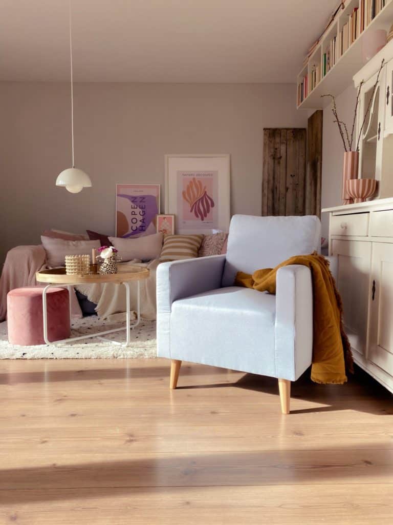 Wohnzimmer im Dopaminestyle mit Scandi-Sessel vor Sofa und Landhaus-Sideboard