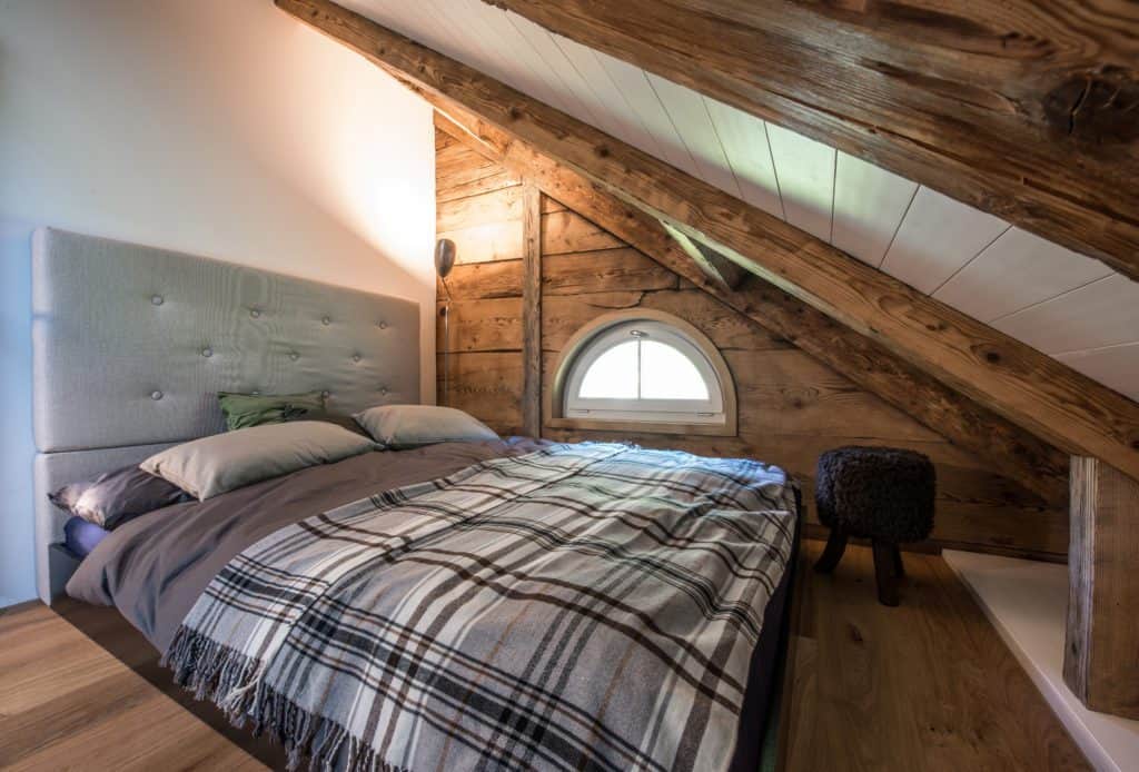 Großes Doppelbett in Dachgeschoss eines 150 Jahre alten, modernisierten Holzhauses 