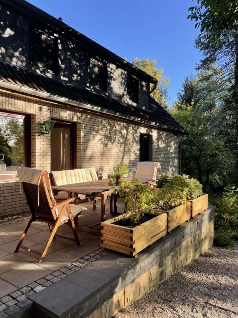 Das koselige Ferienhaus von außen: Die sonnenbeschienene Terrasse.  