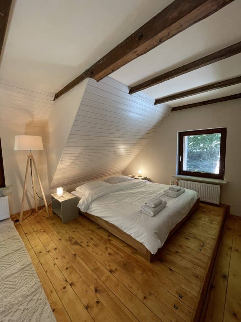 Schlafzimmer im Ferienhaus mit Holzbalkendecke und Dielenboden. 