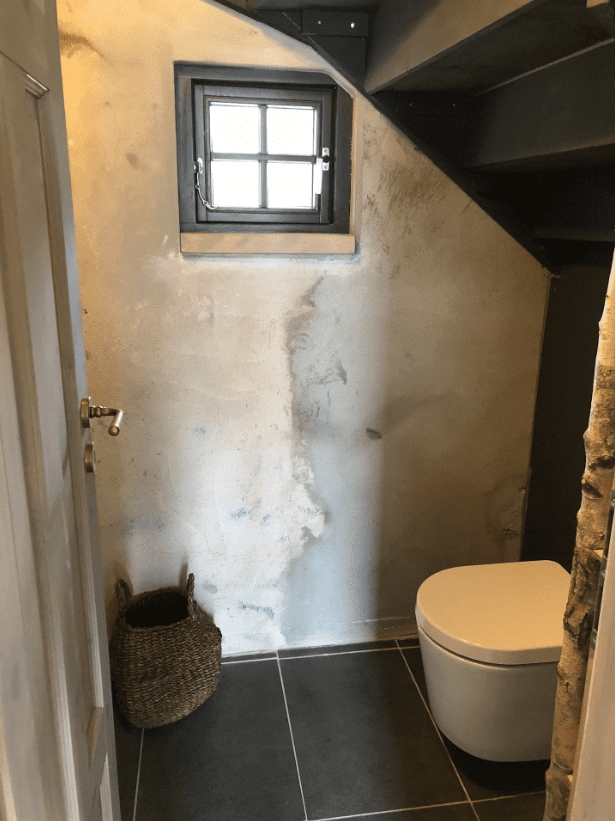 Kleines Gäste-WC im Landhausstil unter der Treppe